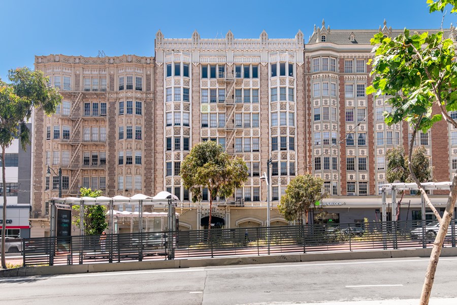 A large, multi-story building with a fence in front of it.